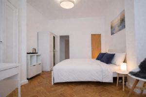 a white bedroom with a bed and a table at Haus Wilbrand Ferienzimmer 2 in Warnemünde