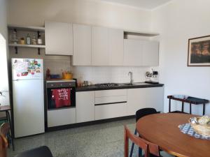 a kitchen with white cabinets and a table with a tableablish at Il Pettirosso alloggio turistico panoramico in Narni