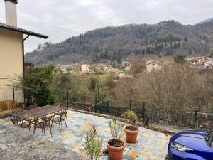 a patio with a table and chairs and a mountain at Ca' del Maglio in Cison di Valmarino