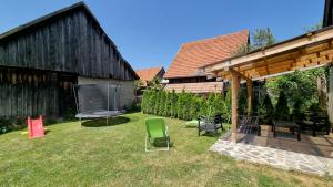 a yard with chairs and a grill and a barn at Drevenica Matilda in Pribylina