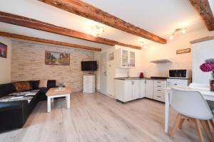 a living room with a black couch and a kitchen at Drevenica Matilda in Pribylina +7 photos