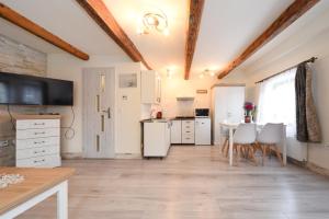 a kitchen with white cabinets and a table and chairs at Drevenica Matilda in Pribylina