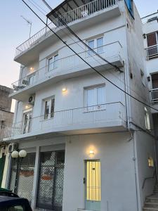 a white apartment building with a yellow door at Central -III- Room in Athens
