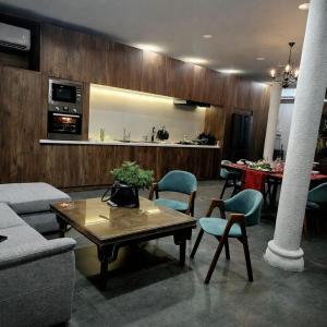 a living room with a table and chairs and a kitchen at Thao’s Villa in Ho Chi Minh City