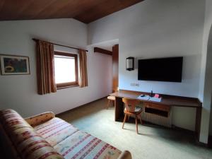 a living room with a couch and a desk with a television at Villa Luise in Ortisei