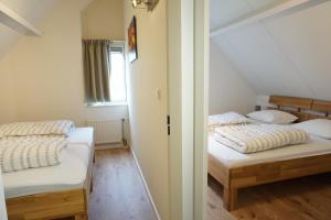 zwei Betten in einem kleinen Zimmer mit Fenster in der Unterkunft Kustverhuur, Breskens Zwin 056 in Breskens + 18 Fotos