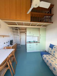 a room with a couch and a table and a kitchen at Cugnana Verde Vacanze in Olbia
