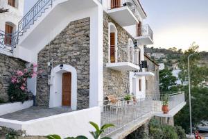 a house with white walls and balconies and flowers at Evdilos blue serenity by BRP-PROPERTIES in Evdilos