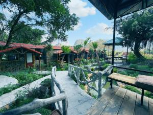 a wooden walkway with a bench in a garden at Trang An Mountain River Ecolodge in Ninh Binh +23 photos