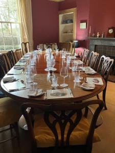a large wooden table with wine glasses on it at Berryhill West Wing- 3 bedroom - 2 bathroom - Self Catering - Sleeps 4 - Dogs Welcome - Off-road Parking - Suit Contractors - Shooting Parties - Peterhead 1 mile - Newly Refurbished - Shed - Yard -Drying Room available in Peterhead +7 photos