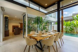 a dining room with a wooden table and chairs at Luxe & Privacy Orchard Villas Pasak 4BR in Laguna Phuket
