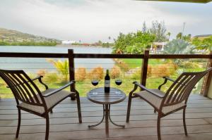 a table with two chairs and a glass of wine on a balcony at Royal St. Kitts Hotel in Frigate Bay