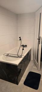 a white bathroom with a black counter and a sink at Rancho U Bodzia in Jeleniów +12 photos