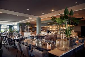 a restaurant with tables and chairs and a library at Van der Valk Hotel Melle - Osnabrück in Melle