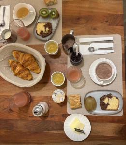 a wooden table with plates of food on it at Les Troglos de la Tufolière in Rochecorbon