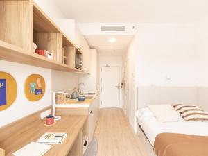 a bedroom with a bed and a desk in it at Canvas Sabadell Llac in Sabadell