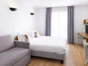a bedroom with a bed and a couch at Aparthotel Adagio Access Paris Maisons-Alfort in Maisons-Alfort +22 photos