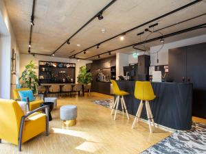 a lobby with yellow and blue chairs and a counter at Limehome Düsseldorf Stresemannstraße - Digital Access in Düsseldorf
