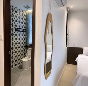 a bathroom with a toilet and a mirror on a wall at The SeaNest Home - Làng Chài Mỹ Tân Ninh Thuận in Vinh Hai +78 photos