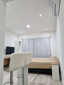 a bedroom with a bed and a desk and a chair at Mirasoles Suites in Monte Grande
