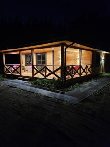a small house with a porch at night at Poleska Przystań in Urszulin +6 photos