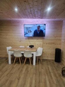 a room with a table and a tv on a wall at Poleska Przystań in Urszulin