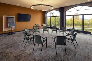 a conference room with chairs and a table and a screen at Van der Valk Hotel Melle - Osnabrück in Melle
