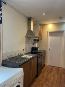 a small kitchen with a stove and a sink at 36 flat 1 - Room 2 in Swansea