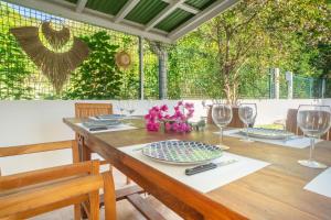 a wooden table with plates and wine glasses on it at Villa Bleue Papaye in Grand-Bourg