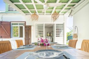 a dining room with a table and chairs at Villa Bleue Papaye in Grand-Bourg