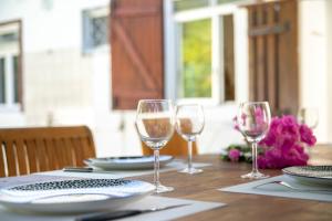 a table with wine glasses and plates on it at Villa Bleue Papaye in Grand-Bourg
