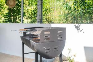 a barbecue grill sitting on top of a patio at Villa Bleue Papaye in Grand-Bourg +30 photos