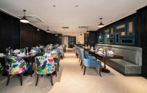 a restaurant with long tables and blue chairs at Luxe Paradise Suites Hotel & Spa in Hanoi