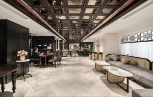 a lobby with a couch and chairs and tables at Luxe Paradise Suites Hotel & Spa in Hanoi