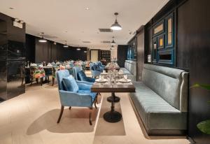 a restaurant with long tables and blue chairs at Luxe Paradise Suites Hotel & Spa in Hanoi