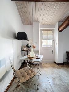 a dining room with a table and chairs and a door at Clos des Cassis - Maison d'Hôtes in Villeneuve