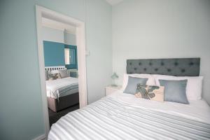 a bedroom with a large bed and a mirror at Cherish Lewis Hotel Blackpool- 2 min to Beach- Smart Lock- Fast WiFi in Blackpool