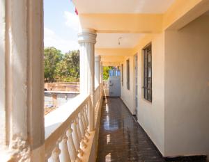 a balcony of a building with columns and a refrigerator at Zariah Homes 1BR Ksm in Kisumu
