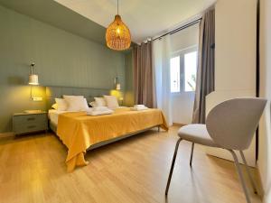 a bedroom with a bed and a chair in it at Humboldt Garden in La Orotava