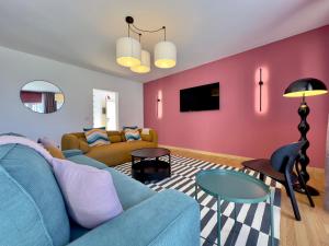a living room with a blue couch and pink walls at Humboldt Garden in La Orotava