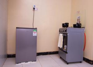 a refrigerator and a stove in a room at Zariah Homes 1BR Ksm in Kisumu +23 photos