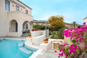 a house with a swimming pool and purple flowers at Villa 1853, Spetses in Spetses