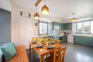 a kitchen with a wooden table and a dining room at Villa 1853, Spetses in Spetses