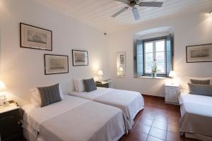 a bedroom with two beds and a window at Villa 1853, Spetses in Spetses +55 photos