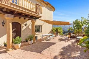 a patio of a house with a table and chairs at Montaña Mimosa B&B in Alhaurín el Grande