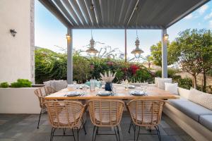 a wooden table and chairs on a patio at Villa 1853, Spetses in Spetses