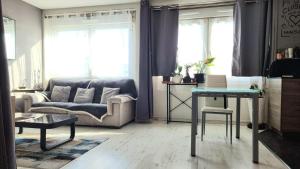 a living room with a couch and a table at Grande chambre de 16m2 in La Croix Rousse
