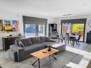 a living room with a gray couch and a table at Newlook 1 in Trélissac