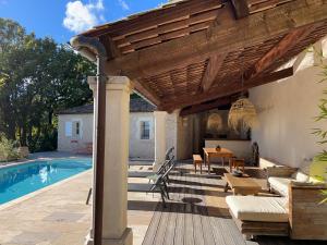 a wooden pergola over a patio with a pool at Clos des Cassis - Maison d'Hôtes in Villeneuve +13 photos