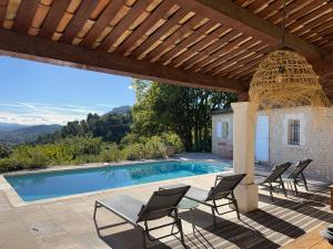 a patio with chairs and a swimming pool at Clos des Cassis - Maison d'Hôtes in Villeneuve